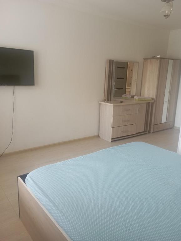 YakkasarayЧавандоz的一间卧室配有一张床、一台电视和橱柜