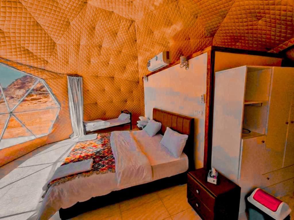 瓦迪拉姆wadi rum camp stars & jeep tour的一间卧室设有一张床和一个大窗户
