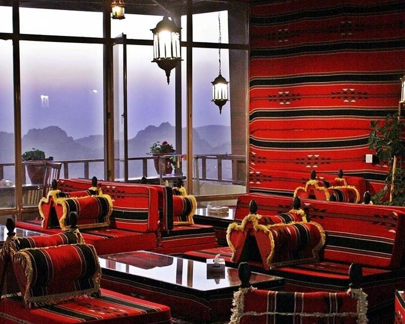 瓦迪穆萨洛矶山酒店 的带红色椅子的客房和山景阳台