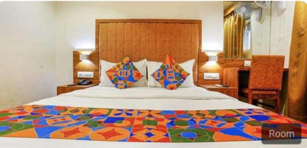 孟买Hotel Royal Palace Kurla的一间卧室配有一张大床和彩色床罩