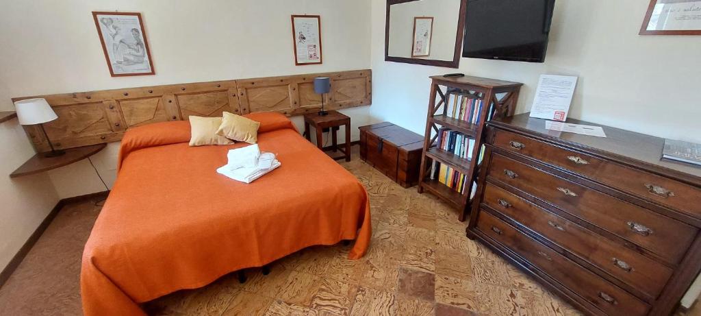 DesanaOryza Casa di Ringhiera的一间卧室配有一张带橙色毯子和梳妆台的床