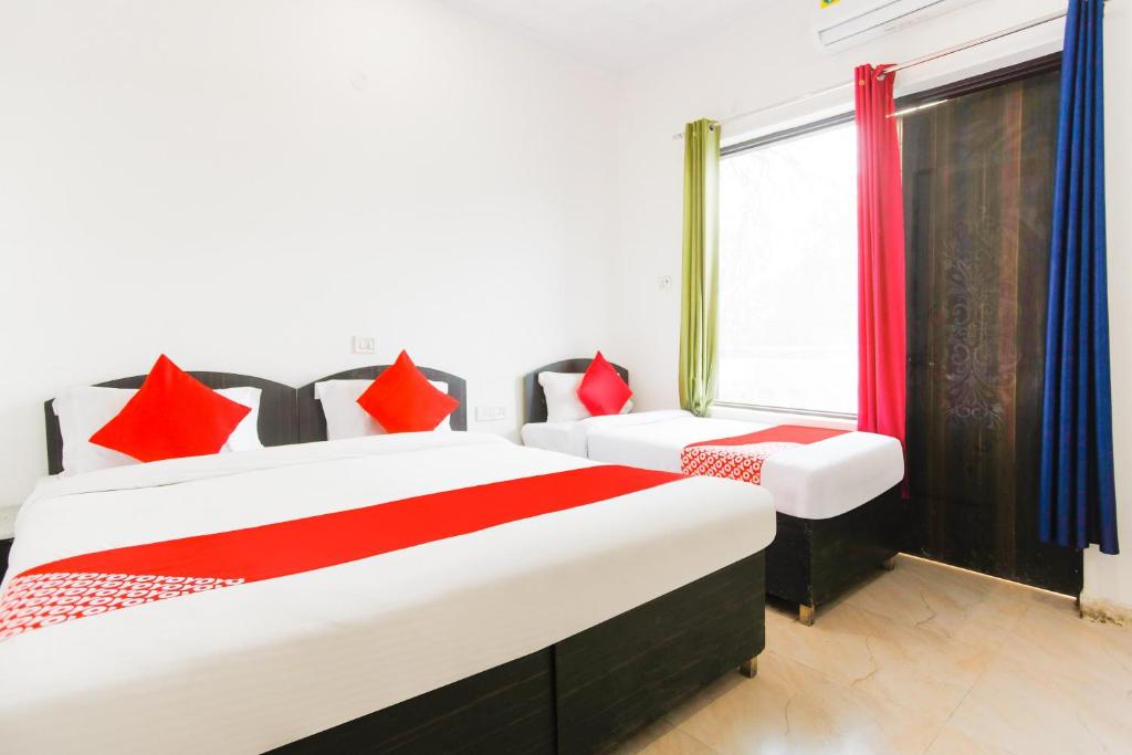 古尔冈OYO Welcome Residency的一间卧室设有两张床和窗户。