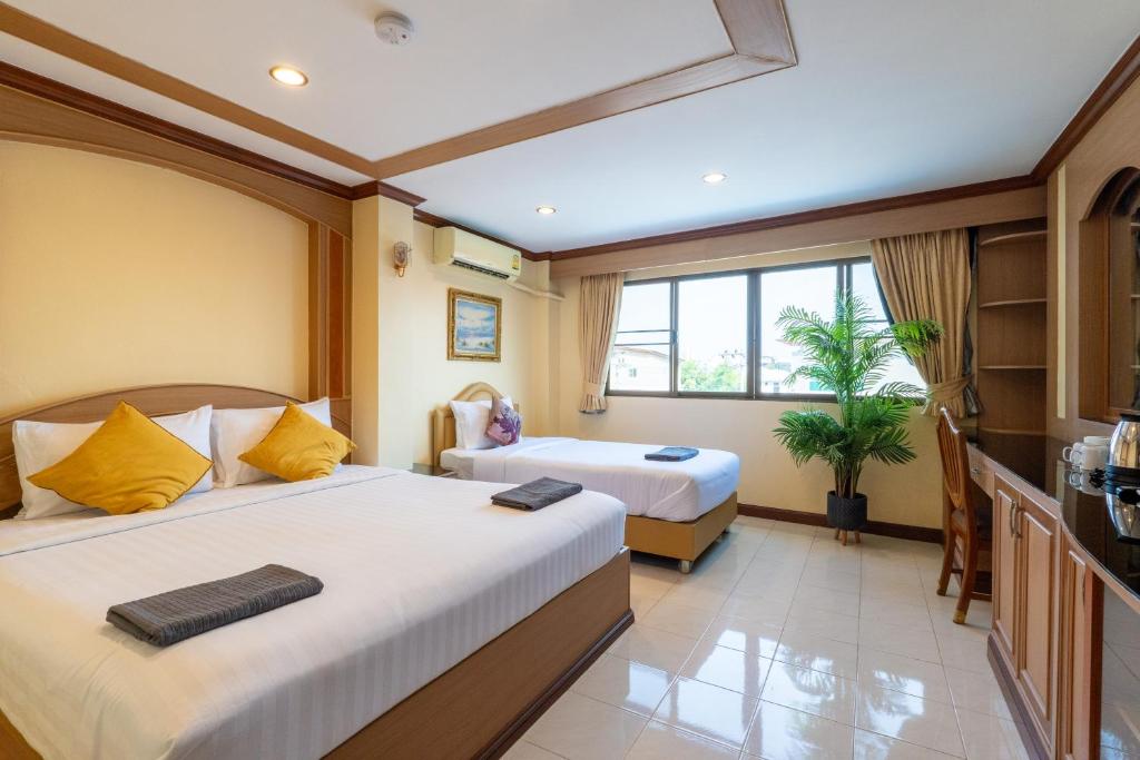 南芭堤雅La Casa South Pattaya Hotel的酒店客房设有两张床和窗户。