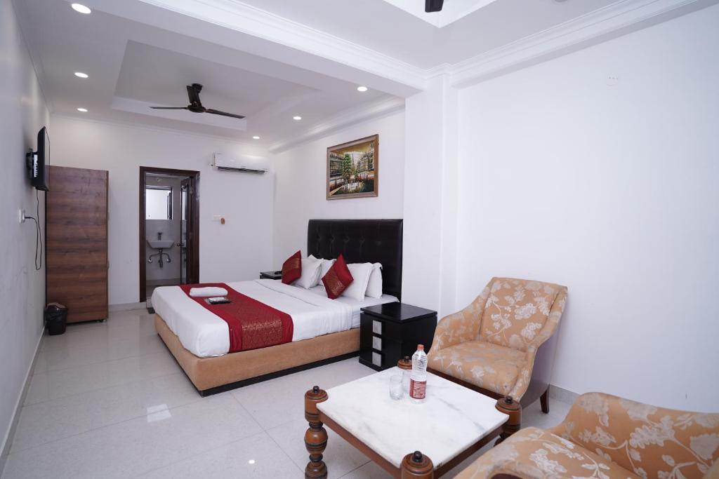 新德里Hotel Moon Taj Near Yashobhoomi Convention Centre的配有一张床和一把椅子的酒店客房