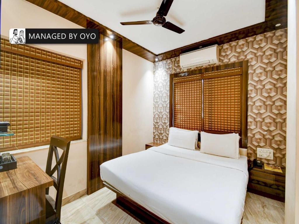 BallygungeTownhouse Imperio Ballygunge Near Park Circus的一间卧室配有一张床、一张书桌和一个窗户。