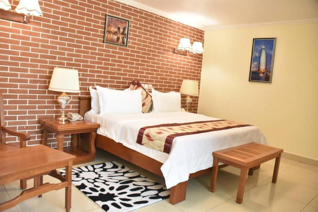 杜阿拉GRAND HOTEL CITY, Douala的一间卧室设有一张床和砖墙