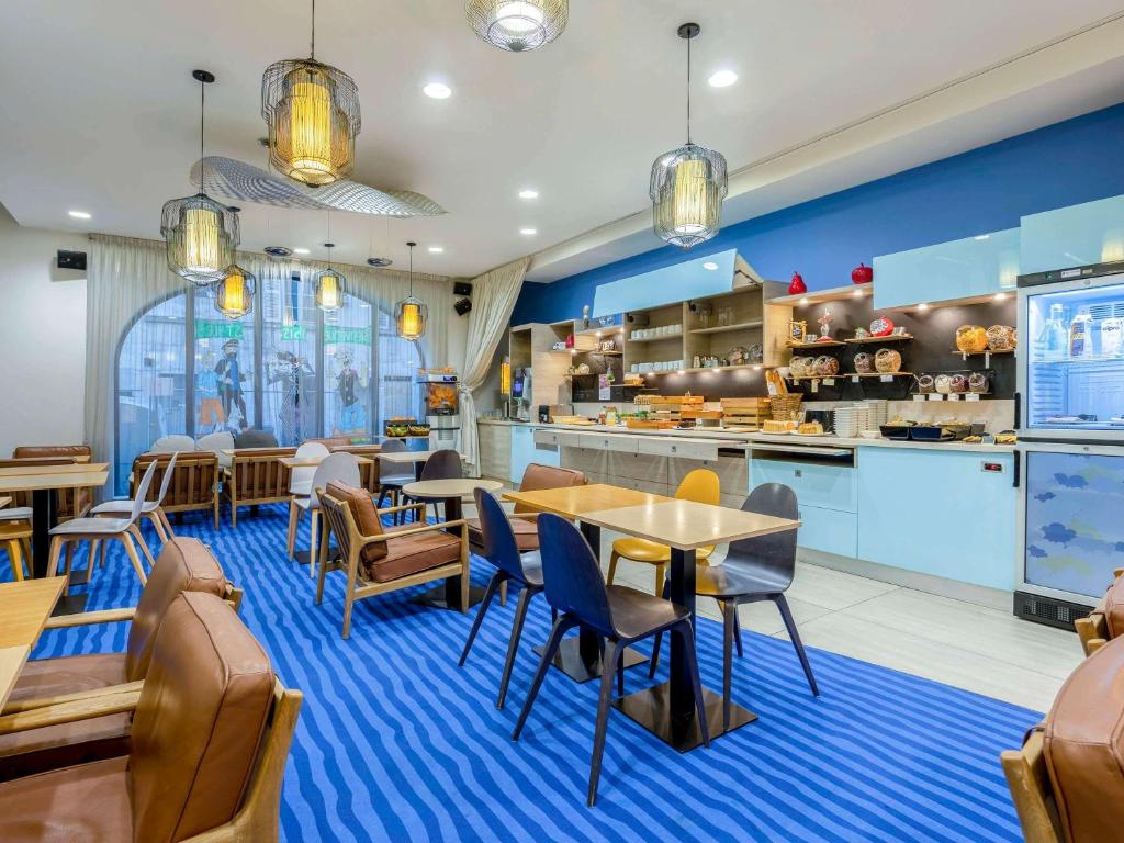 拉罗谢尔拉罗谢尔市中心宜必思尚品酒店的一间带桌椅的餐厅和一间厨房