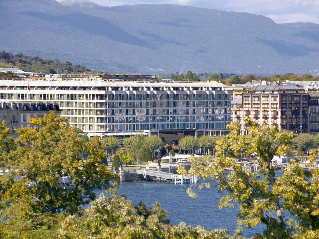 日内瓦Fairmont Grand Hotel Geneva的靠近水体的大建筑