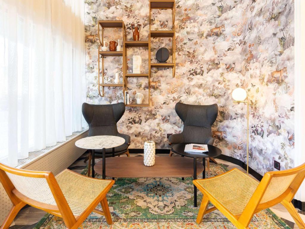 安锡Le Splendid Hotel Lac D'Annecy - Handwritten Collection的墙上的房间里摆放着两把椅子和一张桌子