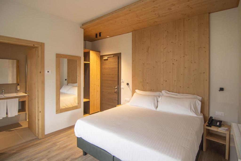LorenzagoChalet Cridola Dolomiti Experience的一间带白色大床的卧室和一间浴室