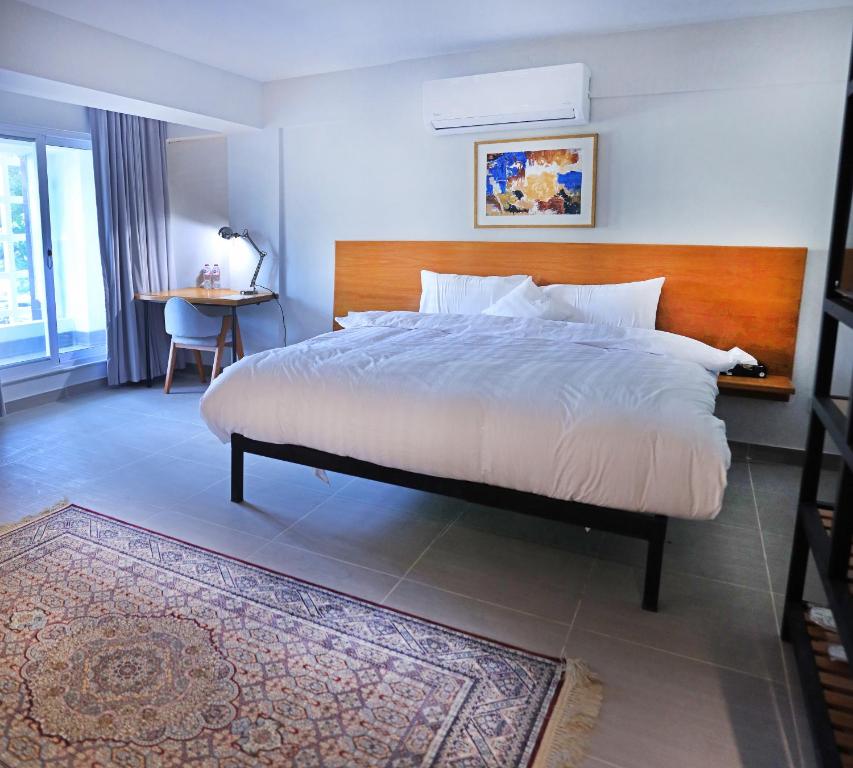 伊斯兰堡The Avenue Hotel的一间卧室配有一张大床和木制床头板