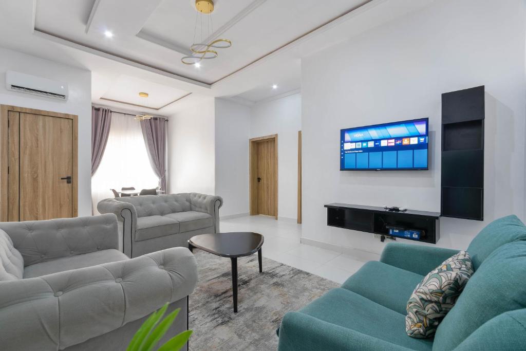 拉各斯Firenze Apartments Lekki的客厅配有2张沙发和1台平面电视