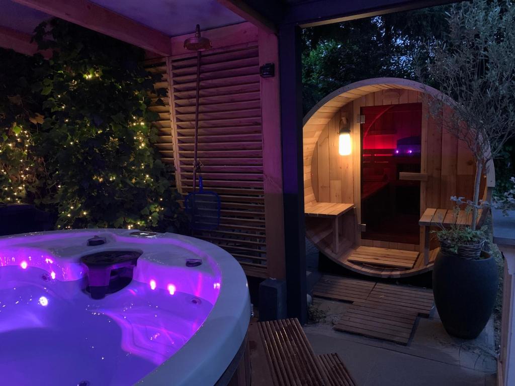 Den HamGanzenmars prive sauna, wellness tub and gamesroom的晚上在后院的按摩浴缸