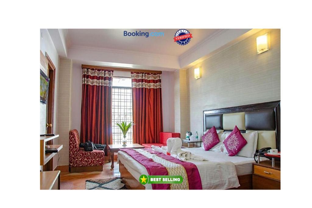 穆索里Hotel Abhinandan Mussoorie Near Mall Road - Parking Facilities & Prime Location - Best Hotel in Mussoorie的酒店客房,配有红色窗帘的床