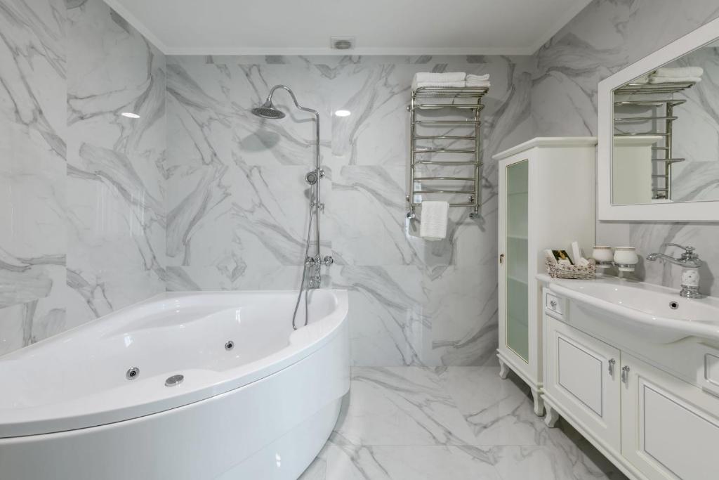 切尔诺夫策Sagora Hotel的白色的浴室设有浴缸和水槽。