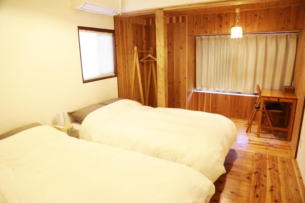鹿儿岛小宿　福右衛門邸的配有木墙和窗户的客房内的两张床