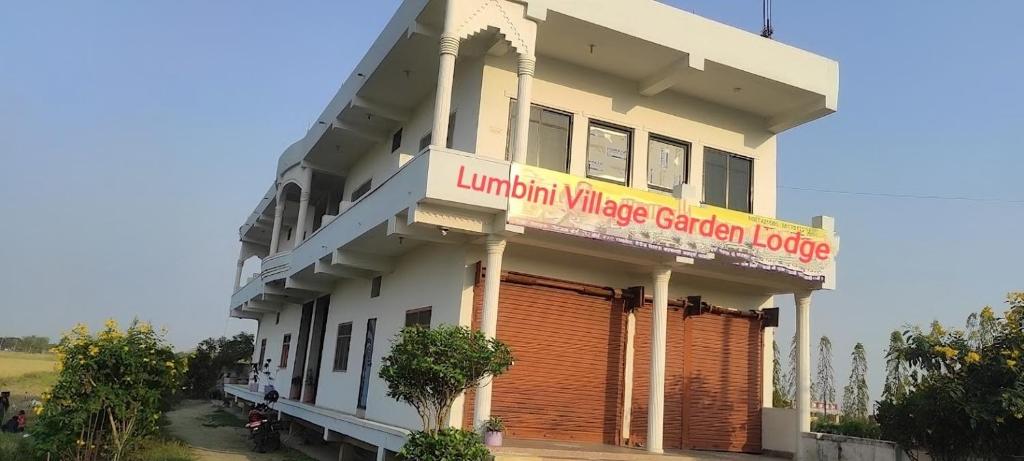 拉明德Lumbini Village Garden Lodge的一座建筑,上面有读取光亮的村庄南部小屋的标志