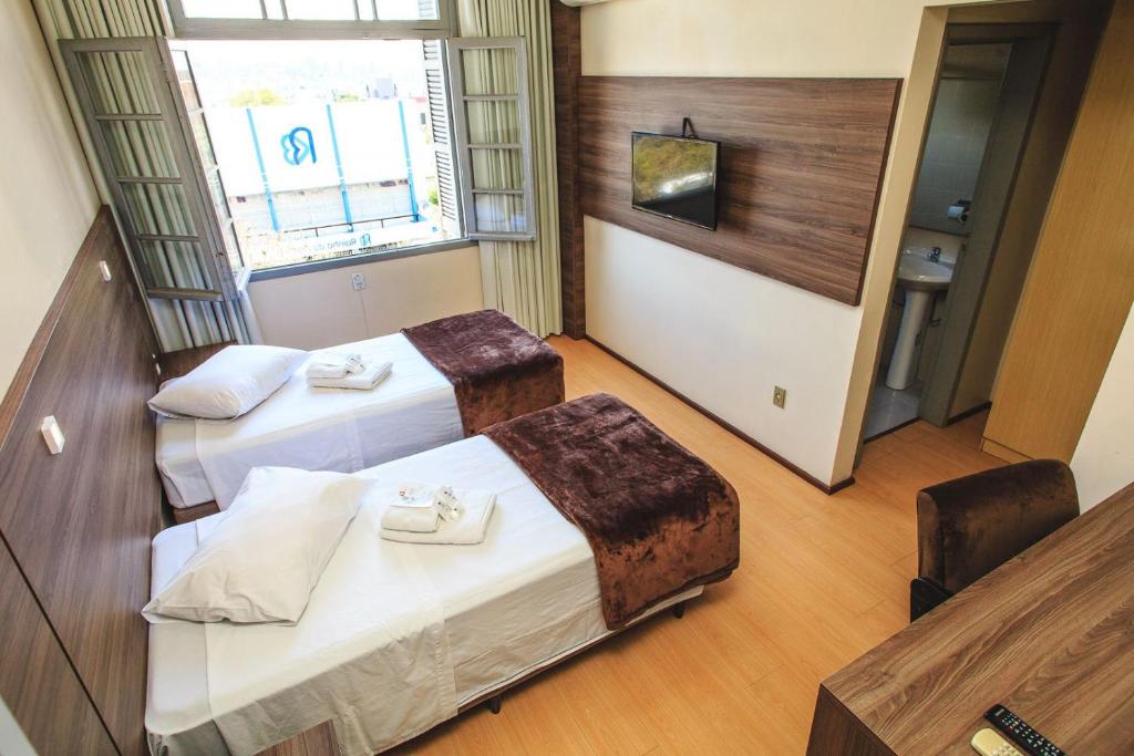 阿雷格里港Pousada Convento São Lourenço的酒店客房设有两张床和电视。