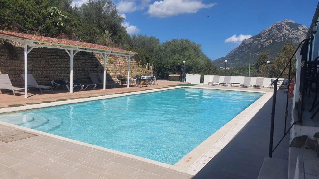 加尔泰利Hotel Valle del Cedrino的庭院里的一个蓝色海水大型游泳池