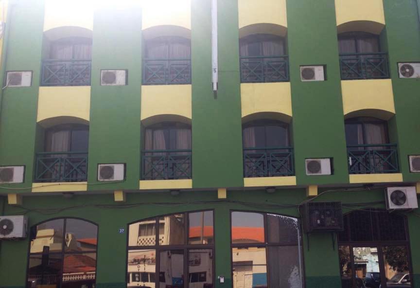 普拉亚Felicidade Hotel的绿色的白色建筑,设有窗户