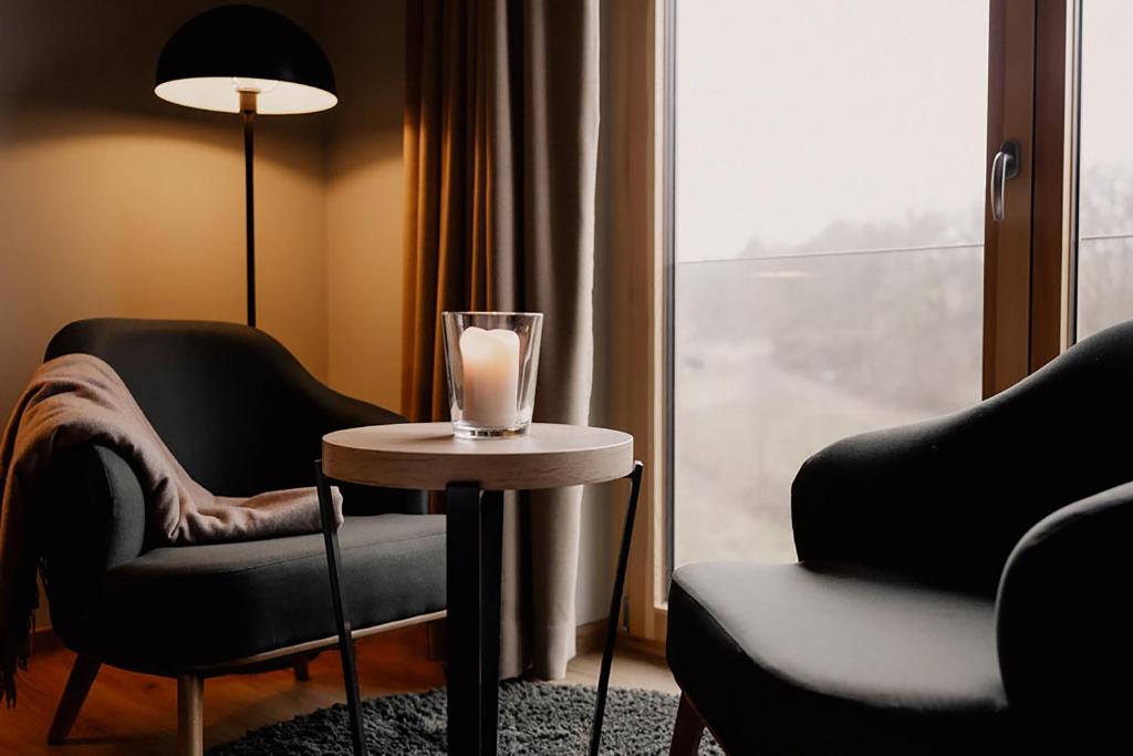莫尔巴赫2tHEIMAT - Hotel & Restaurant的窗户旁的桌子上放着蜡烛的房间