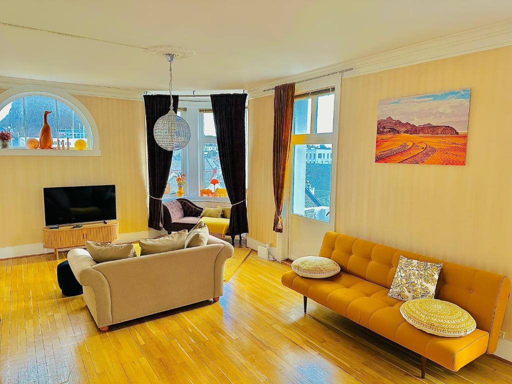 奥勒松Stylish big Jugend art nouveau apartment with balcony heart of Alesund的带沙发和电视的客厅