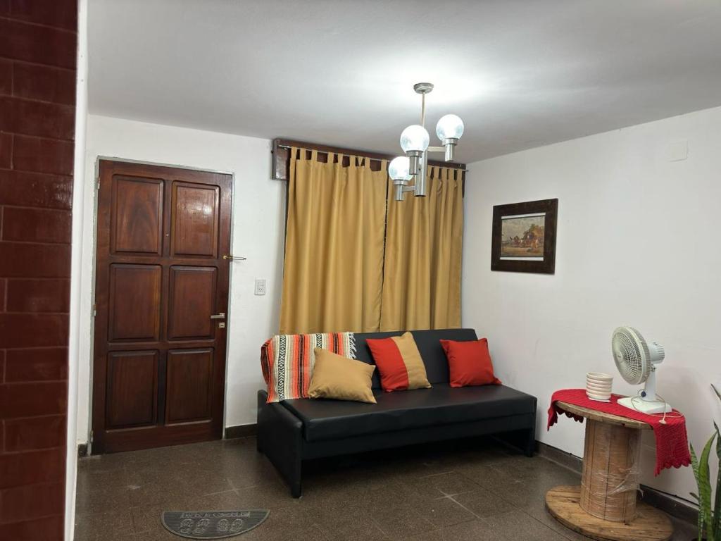 波萨达斯Casa céntrica muy comoda的客厅配有黑色沙发和棕色门