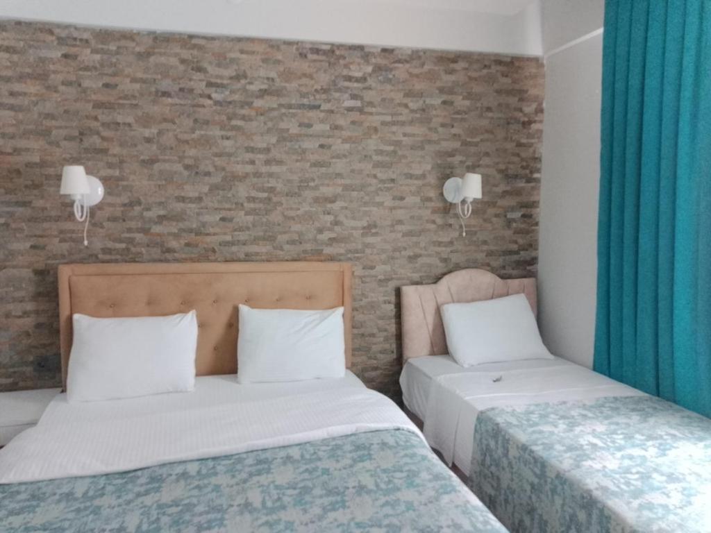 帕莫卡莱The Cotton House Hotel的配有蓝色窗帘的客房内的两张床