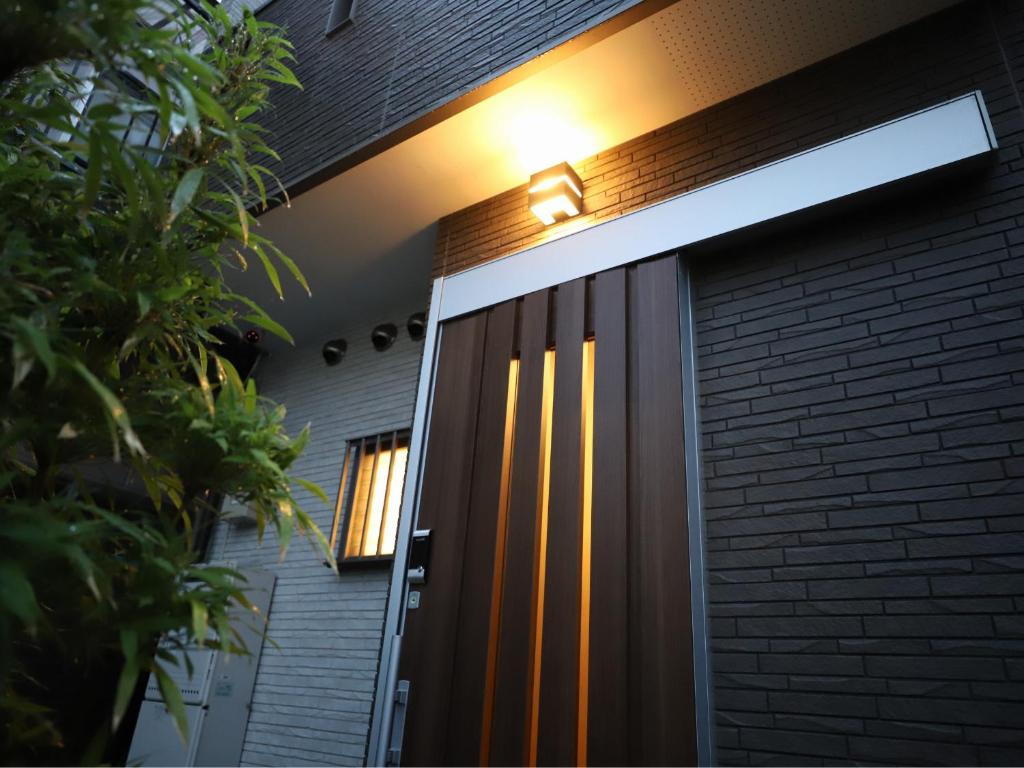 京都一棟貸切り宿 GuestHouse 嵯峨嵐山的房屋前门,上面有灯