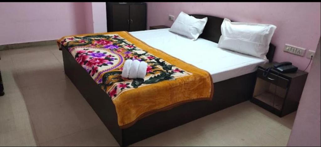斋浦尔HOTEL BITTY KRISHNA的一间卧室配有一张大床和色彩缤纷的毯子