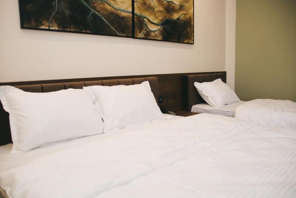 SuharekëHotel Rozafa的一间卧室配有两张带白色枕头的床