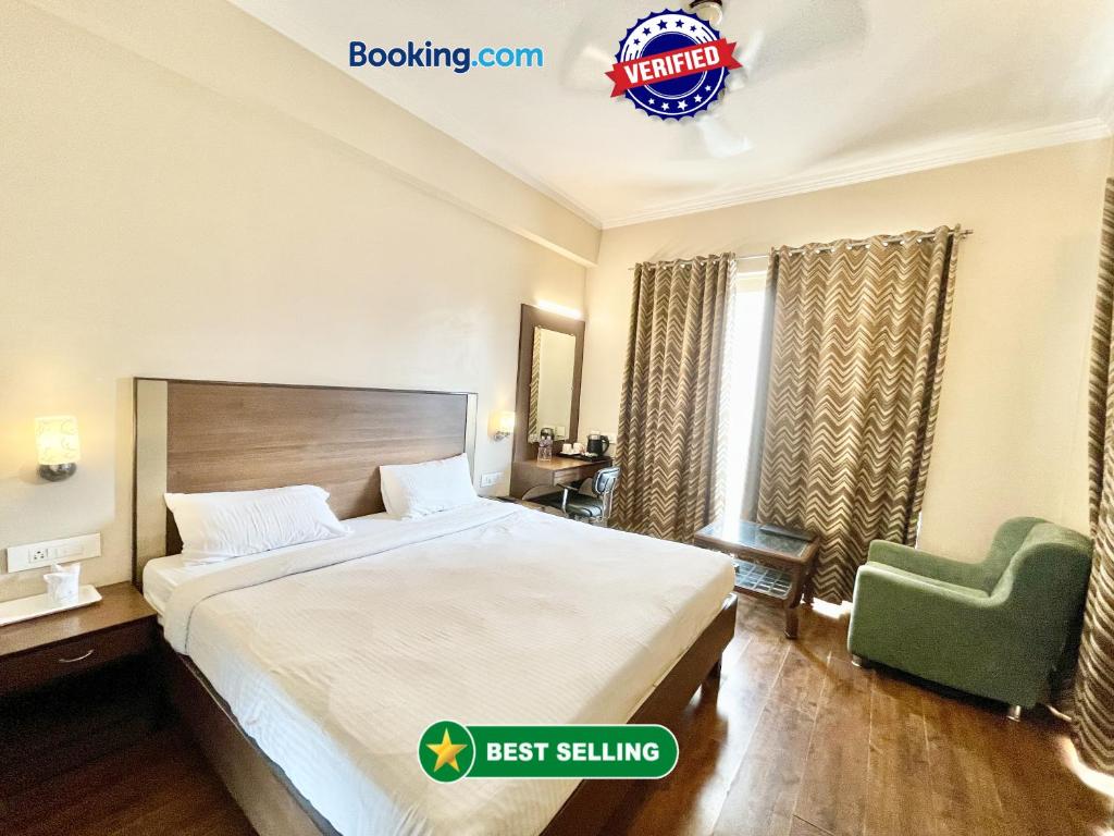 瓦拉纳西HOTEL JANHVEE INN ! VARANASI - Forɘigner's Choice ! fully Air-Conditioned hotel with Parking availability, near Kashi Vishwanath Temple, and Ganga ghat的酒店客房,配有一张床和一把绿色椅子