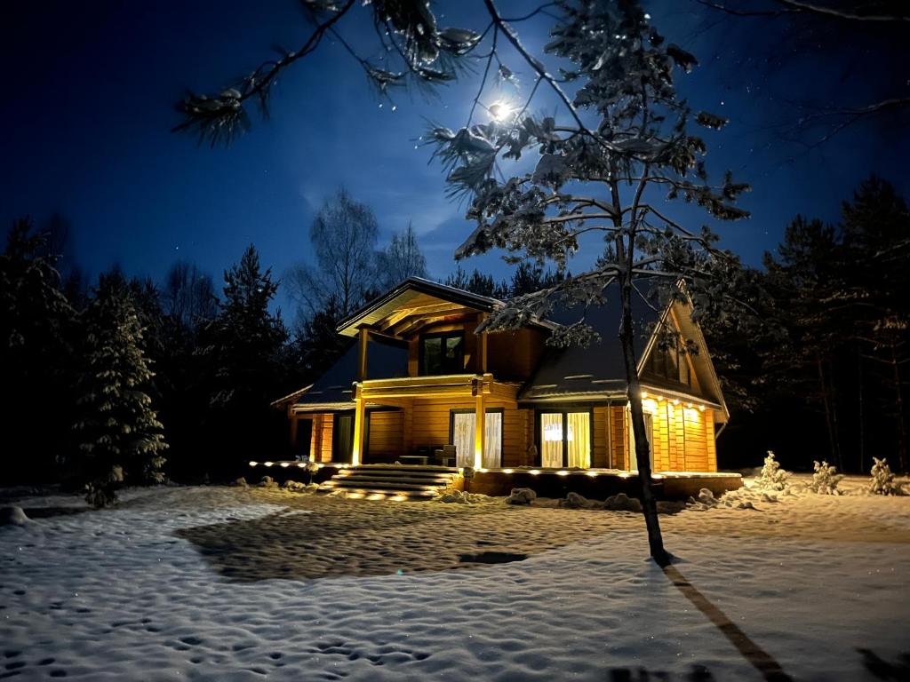 WoodStay的夜晚在雪中点燃的房子