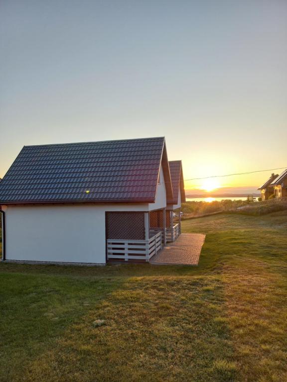 米兹多洛杰Domki na górce的田野上带太阳能屋顶的房子