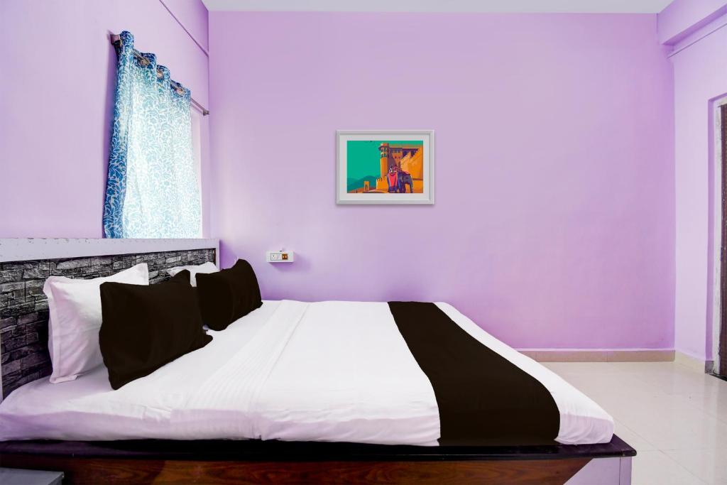 ĀsansolSPOT ON Hotel Sunshine Lodging的一间卧室设有紫色的墙壁和一张大床