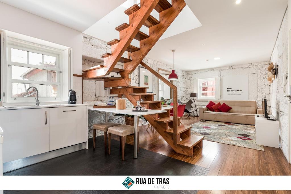 波尔图鲁亚特拉斯公寓的一间厨房和客厅,客厅内配有木制楼梯