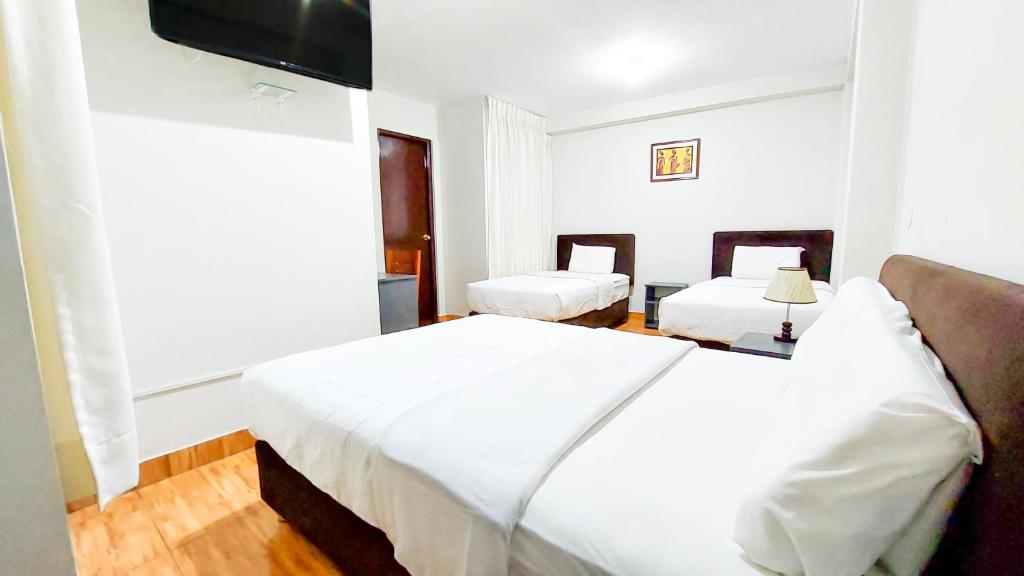 塔克纳Samaná Hs的一间卧室配有两张床和一台平面电视