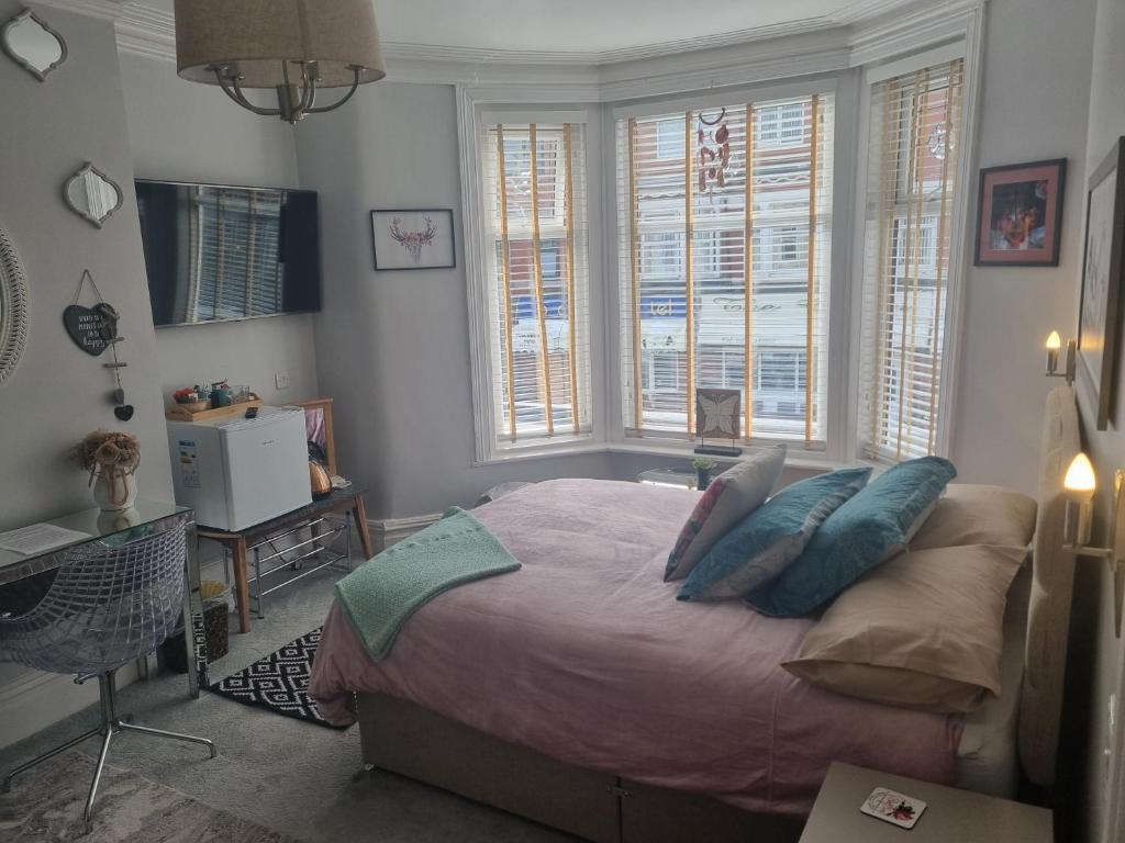 布莱克浦TIFFY'S PLACE Adult Guest House的卧室配有带枕头和窗户的床。