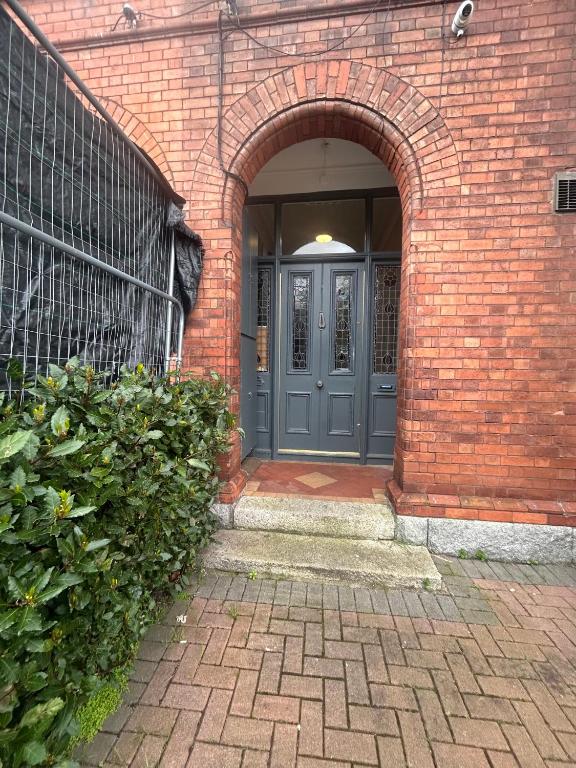 都柏林Superb Location 3 MIN TO RDS, AVIVA, D4 2 BED APARTMENT的拥有蓝色门的砖砌建筑的入口