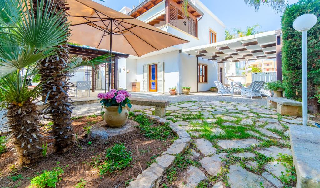 加利波利Baia Verde - Summer Rooms的一个带长凳和遮阳伞的庭院