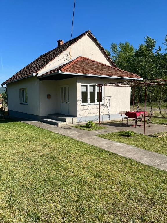 LjubovijaVikendica Lazic的前面有红色长凳的小白色房子