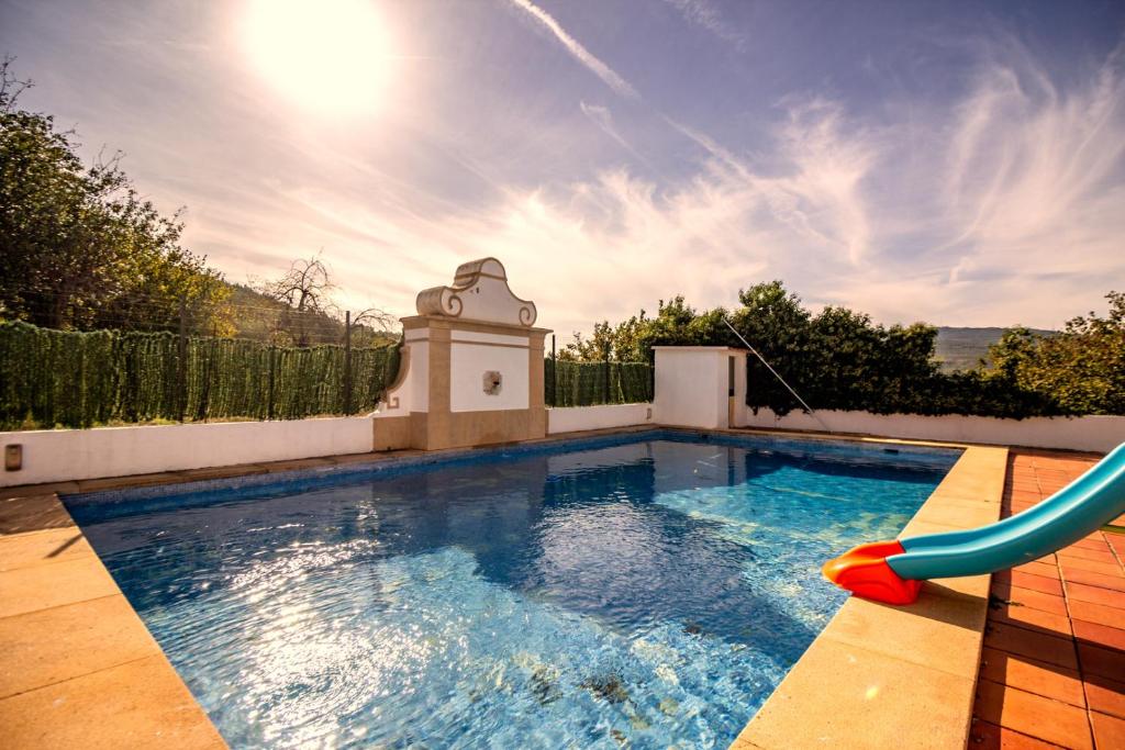 马尔旺Casa Do Ginjal by NaturAlegre的后院带滑梯的游泳池