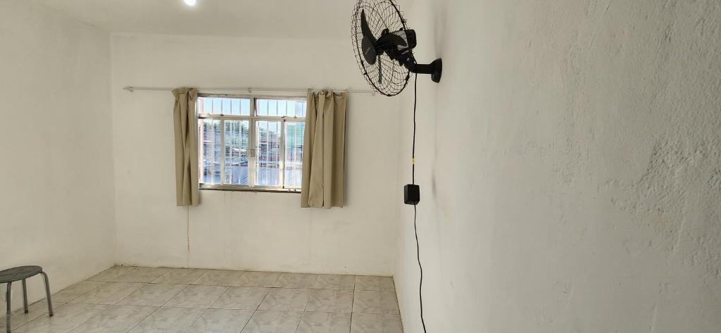 新伊瓜苏Kitinet aconchegante em Nova Iguaçu的白色客房,墙上配有风扇