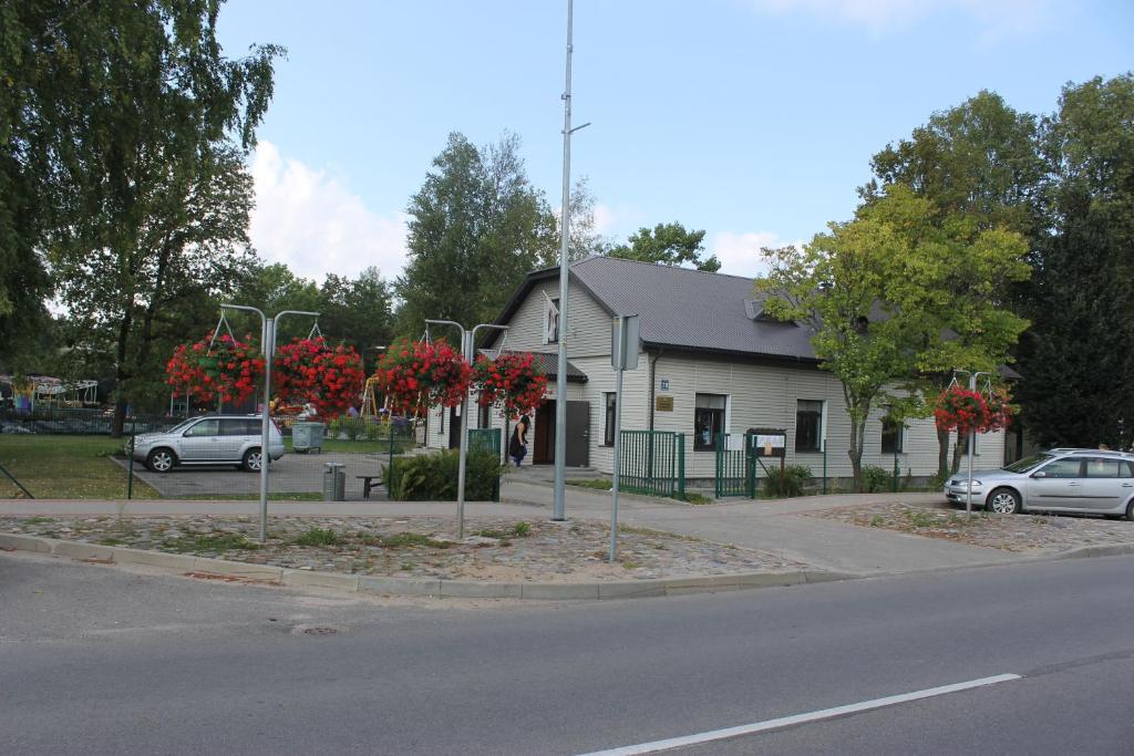 雷泽克内Latvijas Sarkanā Krusta viesnīca的街道前有红花树的建筑
