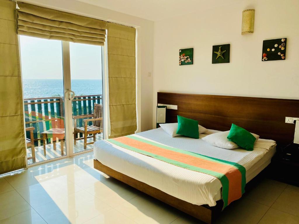 乌斯维塔克伊亚瓦Saprin Beach By Travel Corners的一间卧室设有一张床和一个海景阳台