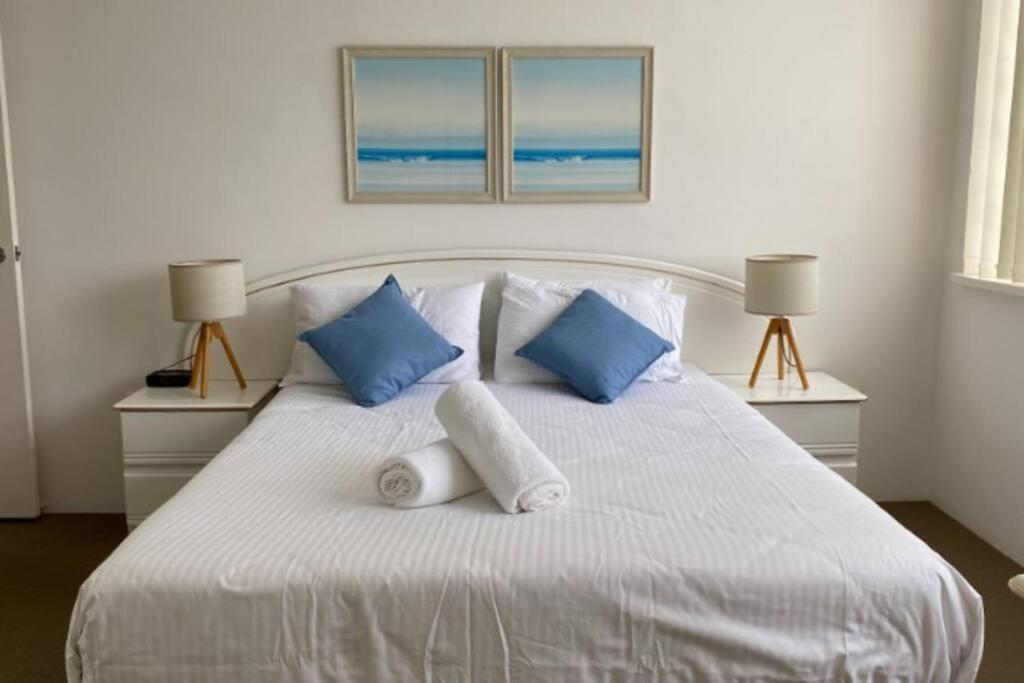 黄金海岸Ocean Front 2Bed - Unbeatable Views @ Sanderling!的一张带蓝色和白色枕头的床和两盏灯