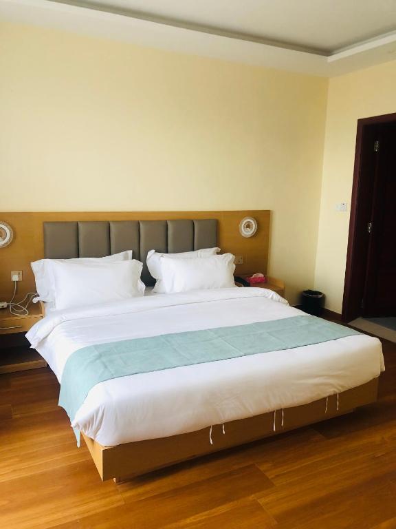 达累斯萨拉姆Fashion International Hotel的卧室配有带白色枕头的大床