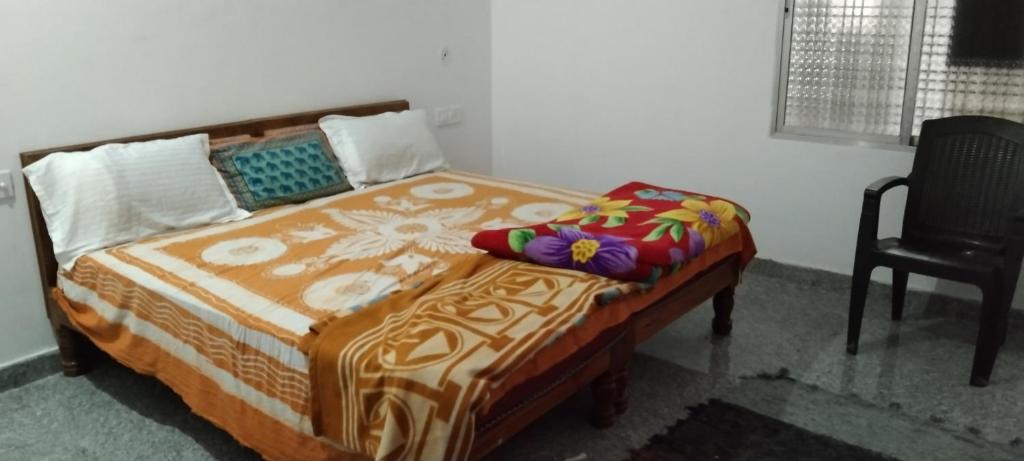 克久拉霍happy khajuraho home stay的一张床位,位于带椅子和床的宿舍间内