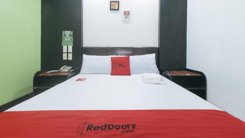 马尼拉RedDoorz at Ranchotel Bayanan Alabang的床上有红色的圆点枕头
