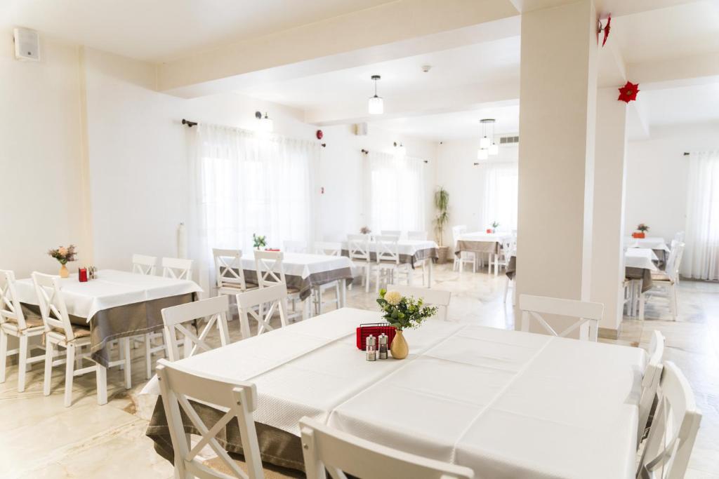 DeseştiPensiunea ROCA Maramureș的用餐室配有白色的桌子和白色的椅子